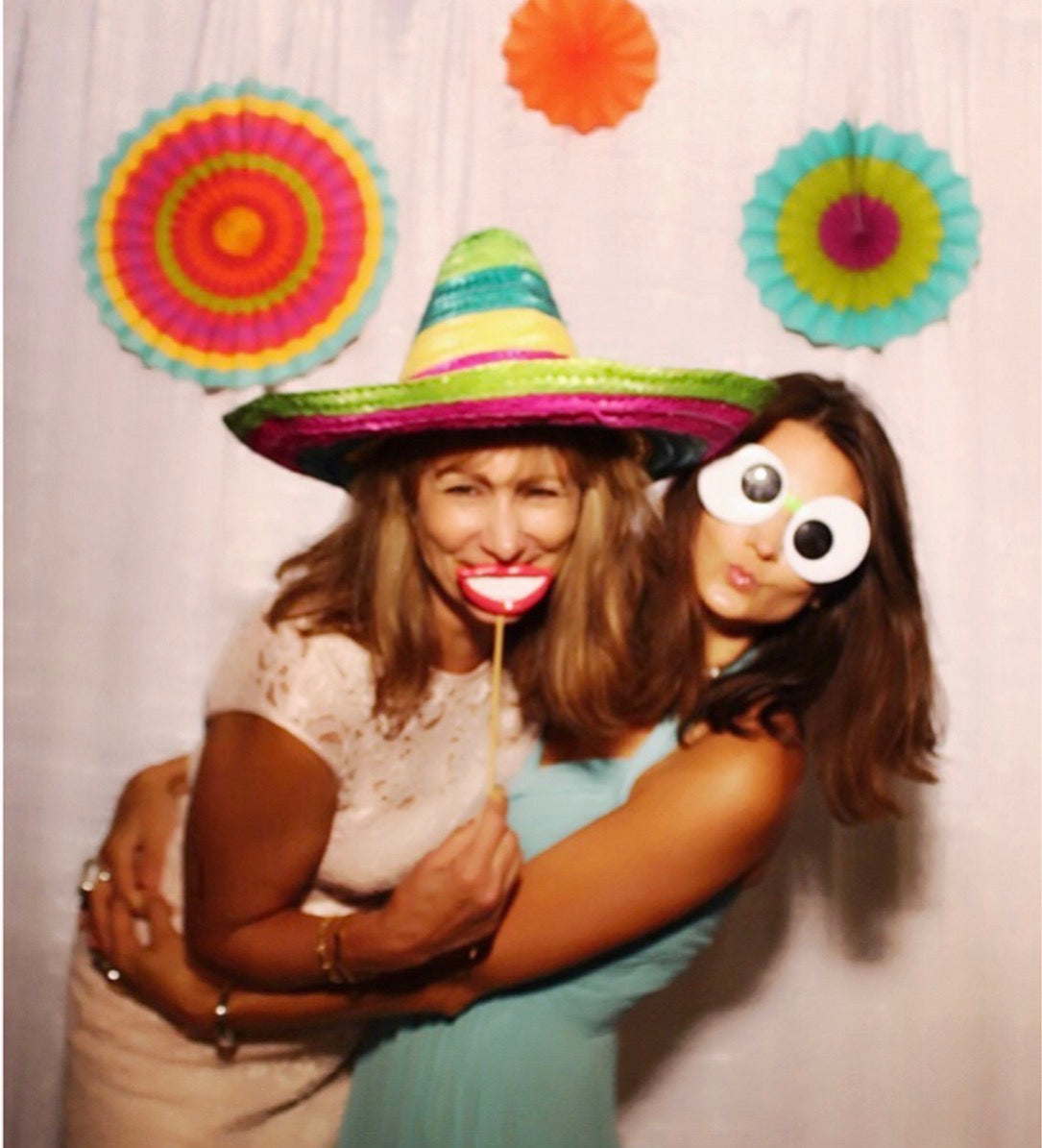 Two family members smiling together with playful party props